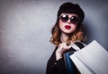 Style redhead girl in hat with shopping bags and sunglasses Royalty Free Stock Photo