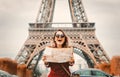 Girl in red coat and bag with map in parisian park Royalty Free Stock Photo