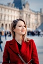 Redhead girl in red coat and bag on parisian street Royalty Free Stock Photo