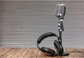 Retro style microphone and headphones on wooben Royalty Free Stock Photo