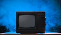 Style retro Tv set with switchers. Old fashioned TV against a smoky studio background with blue neon lights and dust