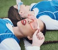 Style, sports and women hockey players relaxing on the grass field with cool, stylish and trendy outfit. Fashion