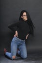 Attractive european girl with black hair and glasses posing in studio on  background. Style, trends, fashion concept. Royalty Free Stock Photo