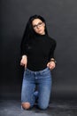 Attractive european girl with black hair and glasses posing in studio on  background. Style, trends, fashion concept. Royalty Free Stock Photo