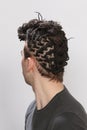 Stylish male model with afro braids posing in studio on isolated background. Style, trends, fashion concept.