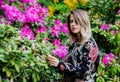 Style woman near rhododendron flowers in a grarden Royalty Free Stock Photo