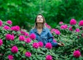 Style woman near rhododendron flowers in a grarden Royalty Free Stock Photo