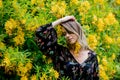 Style woman near yellow flowers in a grarden Royalty Free Stock Photo