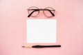 Styled artist workspace on a pale pink pastel background. White paper mock up with space for text. Royalty Free Stock Photo