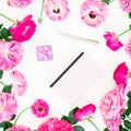 Styled composition with purple roses, ranunculus, notebook, box and pen on white background. Flat lay, top view.