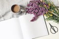 Styled spring breakfast scene, feminine floral composition. Bouquet of purple lilac branches, yellow broom Cytisus, cup