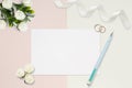 Styled stock photo. Feminine wedding desktop mockup. White roses, satin ribbon, beads on delicate beige background. Copy space. To Royalty Free Stock Photo