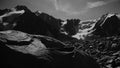 Stylised in an old archived style footage view of mountains with glaciers. 4K bw video with noise and scratches effects.