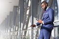 Stylish african american businessman checking his phone in airport terminal Royalty Free Stock Photo