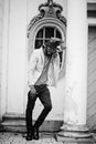 Stylish african american man wear beige jacket and  black hat with sunglasses pose against vintage window Royalty Free Stock Photo