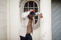 Stylish african american man wear beige jacket and  black hat with sunglasses pose against vintage window Royalty Free Stock Photo