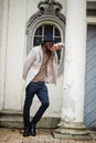 Stylish african american man wear beige jacket and  black hat with sunglasses pose against vintage window Royalty Free Stock Photo