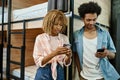 stylish african american roommates using smartphones