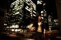 Stylish african american woman in night city. Woman standing with hand on waist with eyes closed