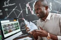 Move forward to be financially constant. Close up of stylish african businessman, trader sitting by desk in front of