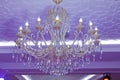 Stylish antique chandelier. Horizontally framed shot . Stylish antique chandelier lit in violet light. beautiful crystal chandelie