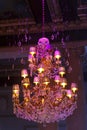 Stylish antique chandelier lit in violet light.