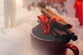 stylish aromatic cinnamon sticks on red cup on white background, seasonal greetings Royalty Free Stock Photo