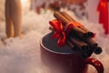 stylish aromatic cinnamon sticks on red cup on white background, seasonal greetings Royalty Free Stock Photo