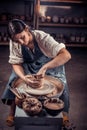 Beautiful craftsman posing while making earthenware. Manual work.