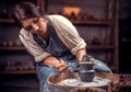 Charming handicraftsman making ceramic pot on the pottery wheel . The concept of craft creativity.