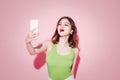 Stylish asian woman taking selfie photo on pink background. Royalty Free Stock Photo