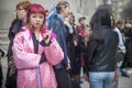 Stylish attendees gathering outside 180 The Strand for London Fashion Week. A girl with pink hair in purple culottes and a pink q Royalty Free Stock Photo