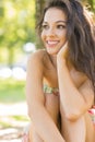 Stylish attractive brunette sitting under a tree