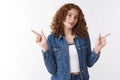 Stylish attractive cool urban college girl freckles pimples redheaded, pointing left right sideways different sides Royalty Free Stock Photo