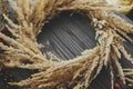 Stylish autumn boho wreath with dry grass, wildflowers, herbs, berries on rustic wooden background. Making rustic autumn wreath,