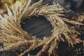 Stylish autumn boho wreath with dry grass, wildflowers, herbs, berries on rustic wooden background. Making rustic autumn wreath, Royalty Free Stock Photo