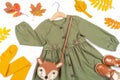 Stylish autumn set of child clothes. Green dress, brown bag, shoes and yellow tights, accessories for hair and autumn