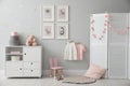 Baby room interior with chest of drawers and cute pictures on wall Royalty Free Stock Photo