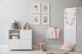 Baby room interior with chest of drawers and cute pictures on wall Royalty Free Stock Photo