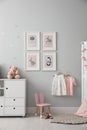 Baby room interior with chest of drawers and cute pictures on wall Royalty Free Stock Photo