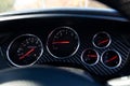 Stylish backlit dashboard with sensors for measuring speed, engine temperature and pressure against a blue and black chess Royalty Free Stock Photo