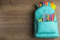 Stylish backpack with different school stationary on wooden table, top view Royalty Free Stock Photo