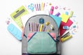 Stylish backpack with different school stationery on background, top view Royalty Free Stock Photo