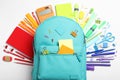 Stylish backpack with different school stationery on white background, top view Royalty Free Stock Photo