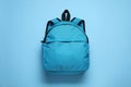 Stylish backpack on light blue background, top view