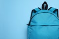 Stylish backpack on light blue background, top view. Space for text