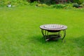 A stylish barbecue grill stands in the middle of the courtyard or garden on the green lawn grass. Copyspace