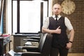 Barber invites to have seat on chair at barbershop