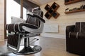 Stylish barbershop interior with professional armchair and modern wash unit