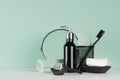 Stylish bathroom interior with black shaving accessories on green wall, white table - razor, toothbrush, mirror, towel, soap. Royalty Free Stock Photo